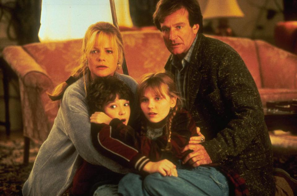 a family sitting on the floor in front of a couch