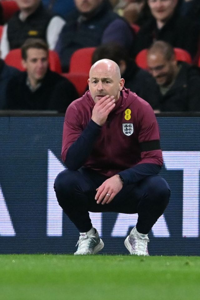 a man squatting on a soccer field with an eee logo on his shirt