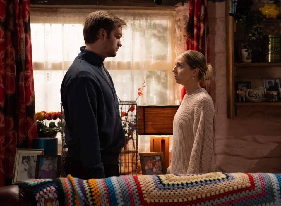 a man and a woman are looking at each other in a living room