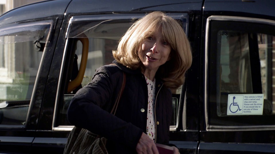 a woman getting out of a taxi with a handicap sign on the door