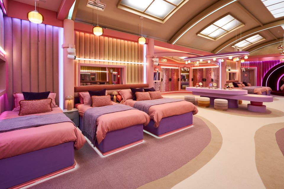 a bedroom with pink and purple beds and a vanity