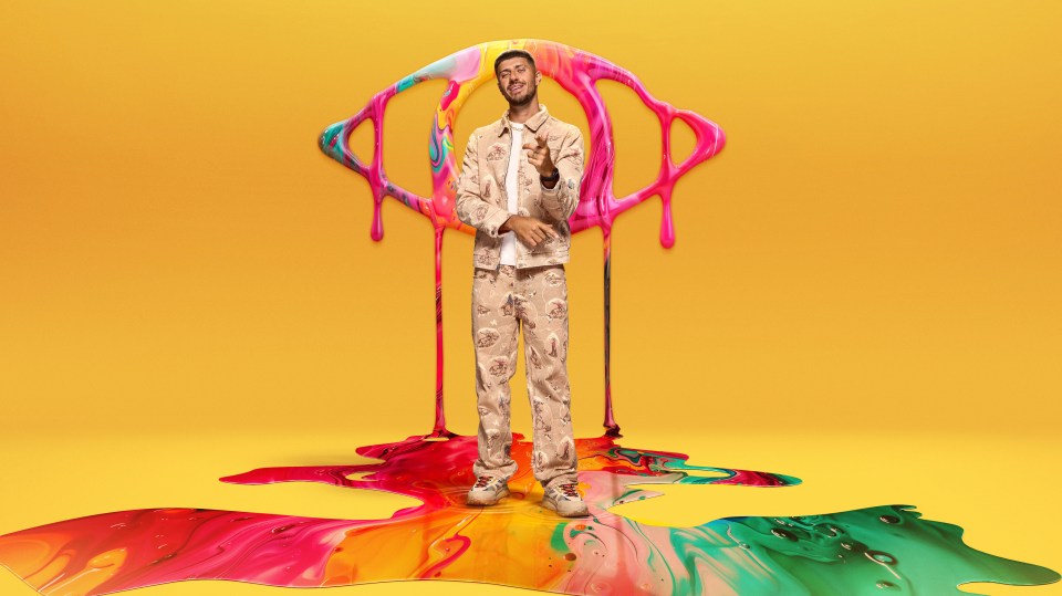 a man is standing in front of a colorful painting