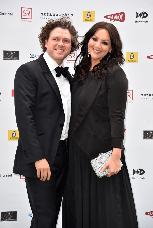 a man and woman are posing for a picture in front of a wall that says film ahoy