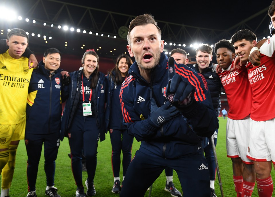 a group of soccer players are posing for a picture with a man wearing an adidas jacket