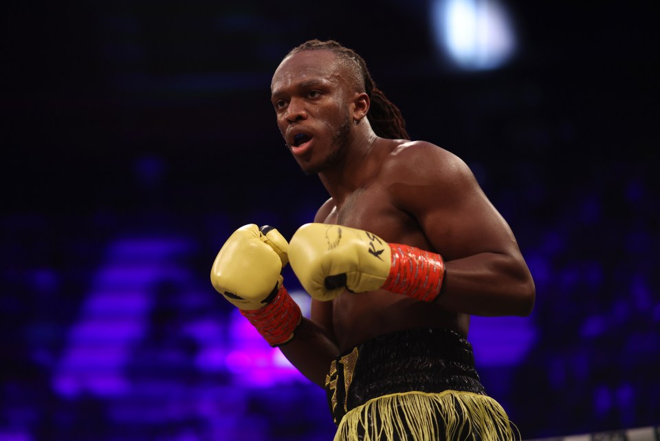 a man wearing yellow boxing gloves with the letter k on them