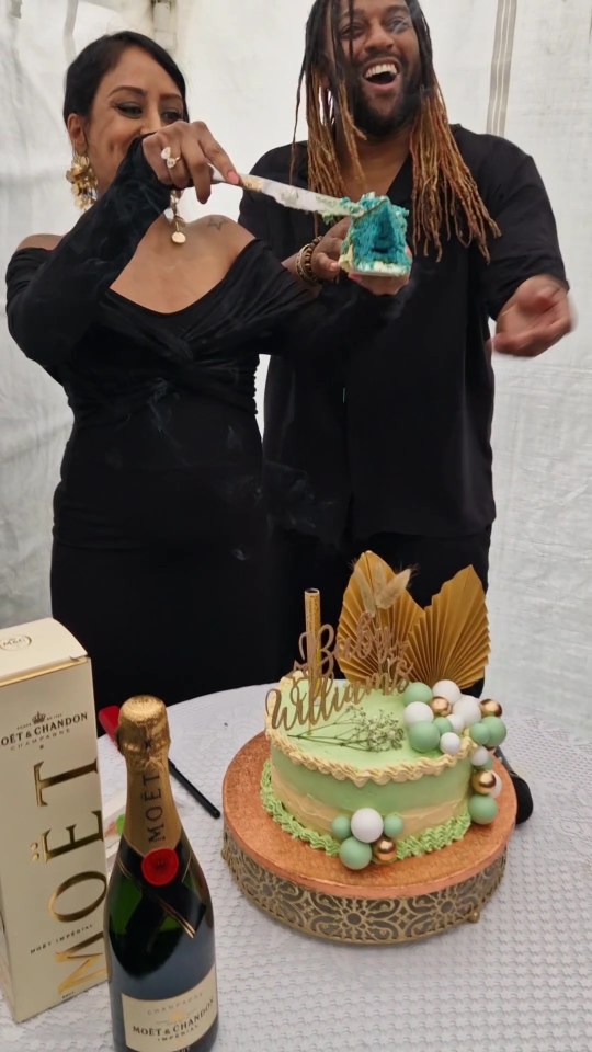 a man and woman are cutting a cake next to a bottle of moet & chandon