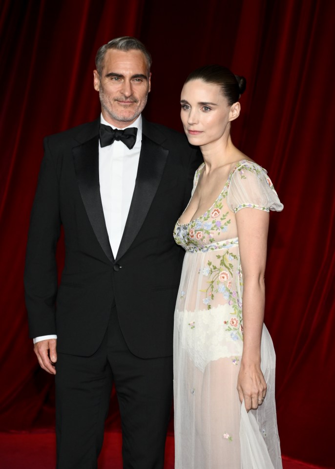 a man in a tuxedo stands next to a woman in a white dress