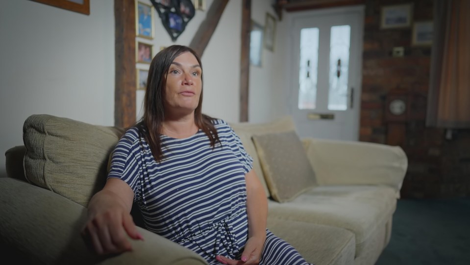 a woman in a striped dress sits on a couch