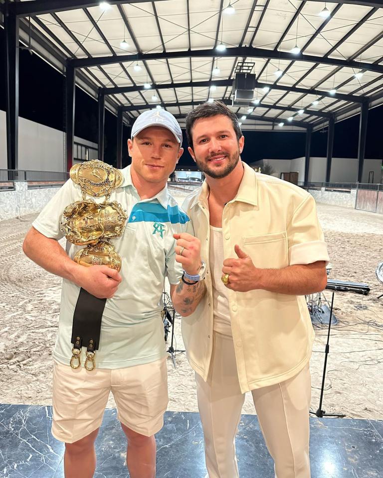 two men posing for a picture with one wearing a shirt with the letter a on it