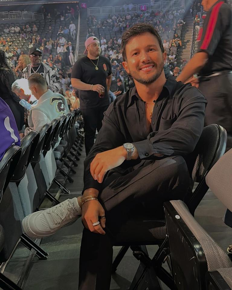 a man sits in a stadium with his feet crossed