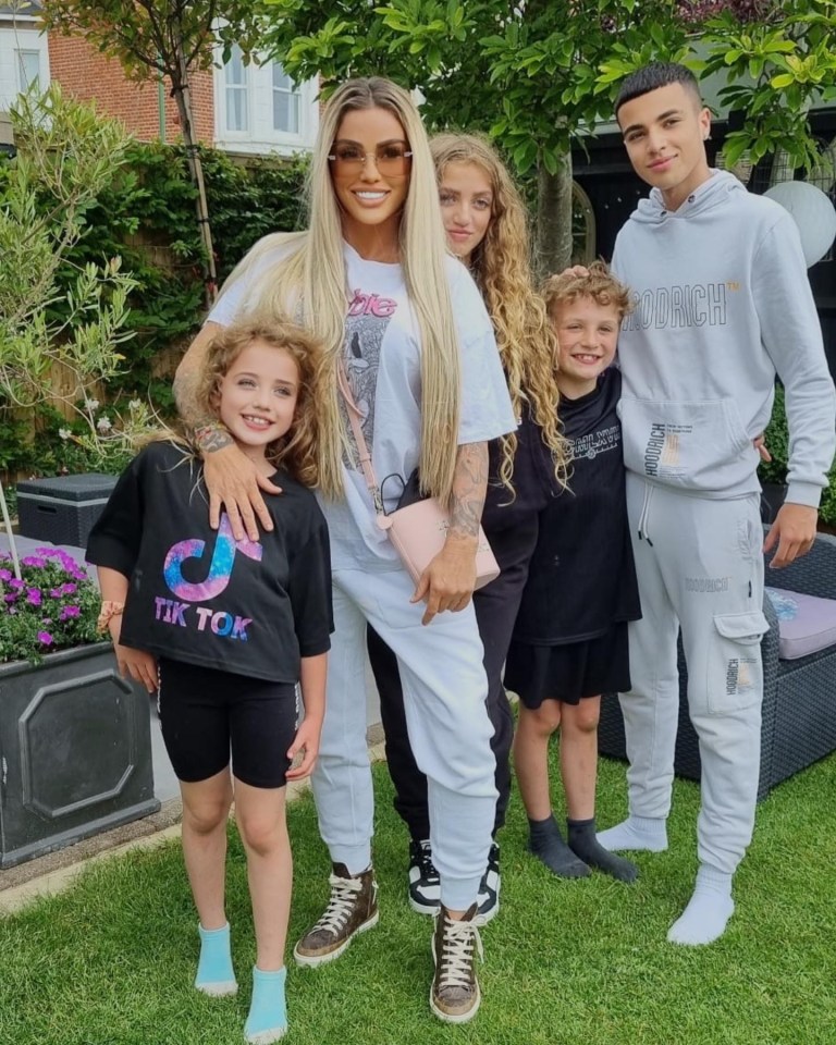 a woman wearing a tik tok t-shirt poses with her children