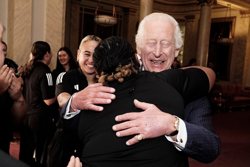 King Charles embracing New Zealand rugby players at a reception last month