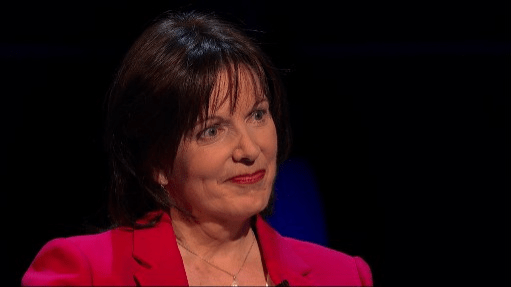 a woman in a red jacket is sitting in front of a black background .