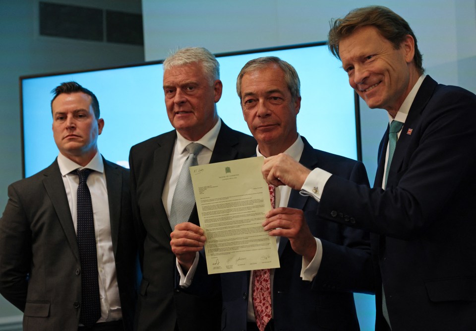 a man in a suit is holding a piece of paper that says ' parliament of the united kingdom ' on it