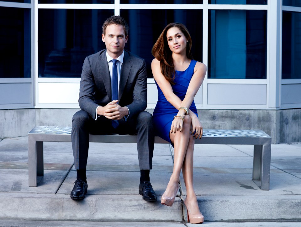 a man in a suit and tie sits next to a woman in a blue dress