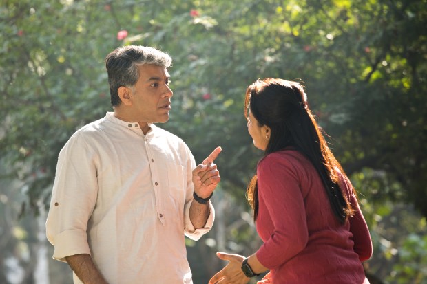 a man in a white shirt is pointing at a woman in a red shirt