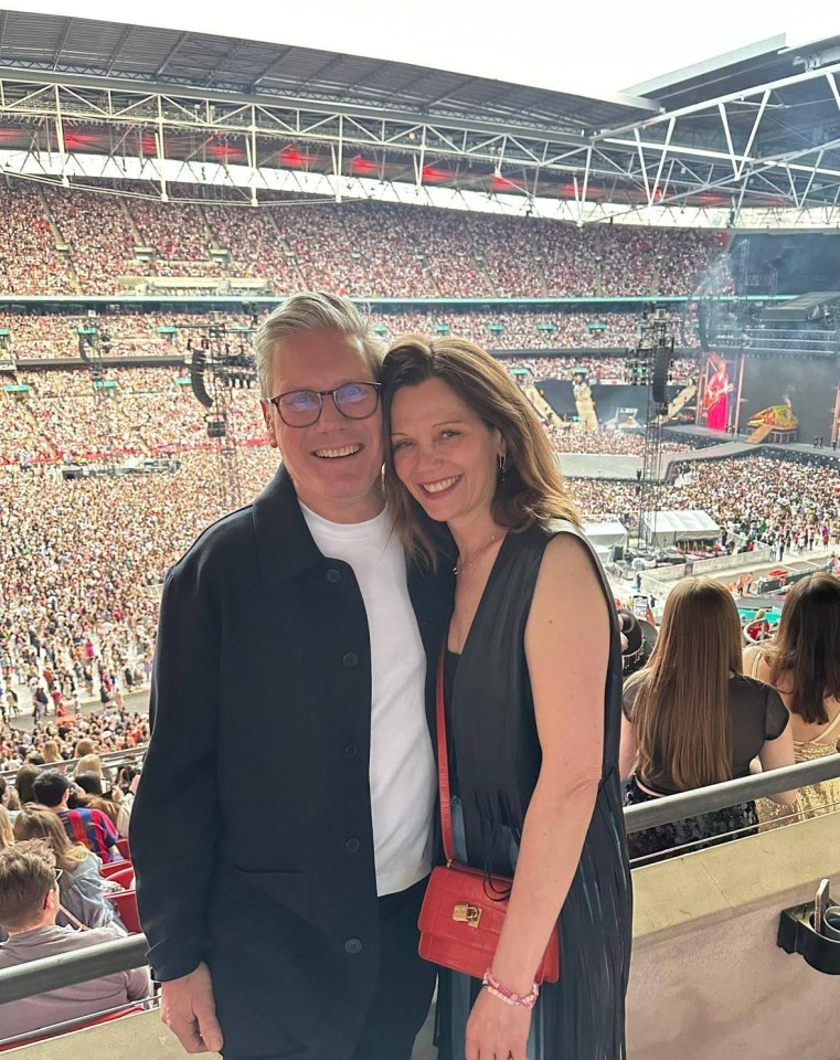 a man and a woman are posing for a picture in a stadium