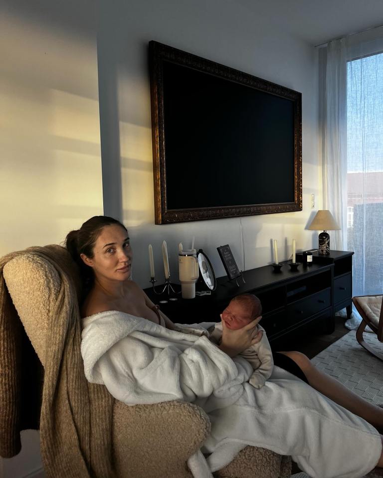 a woman is sitting in a chair holding a baby