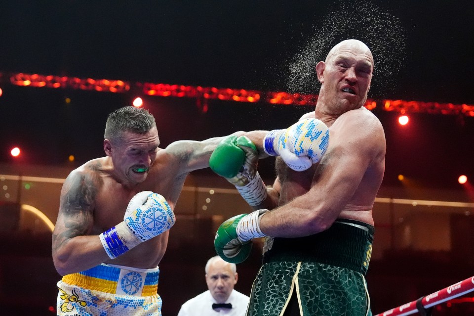 two boxers in a ring with one wearing a belt that says fury