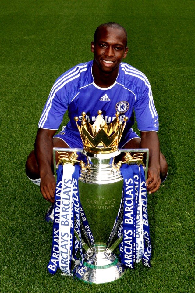 a soccer player poses with the barclays trophy