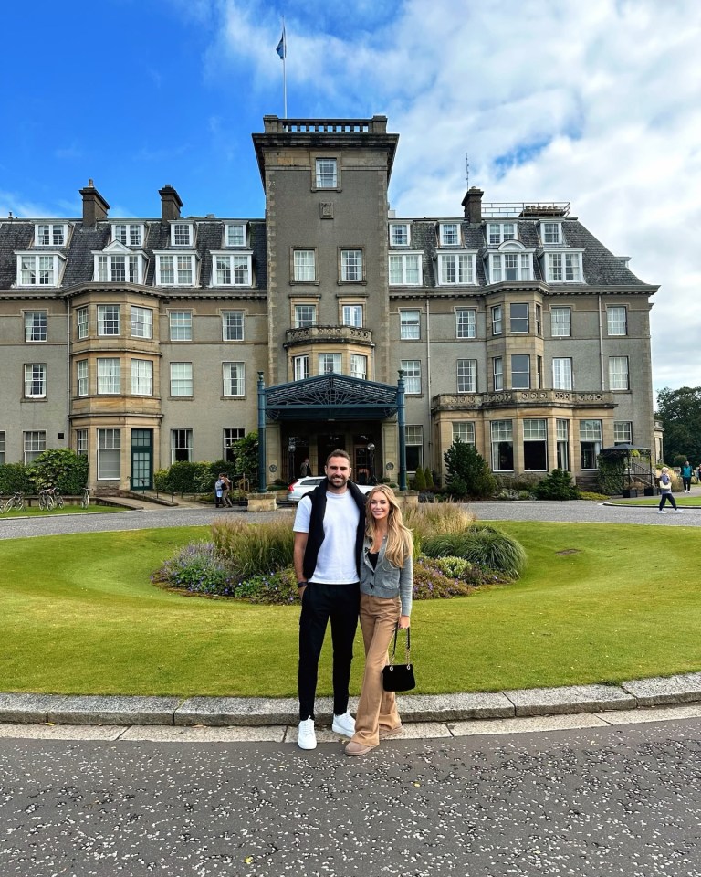 a man and woman standing in front of a large building