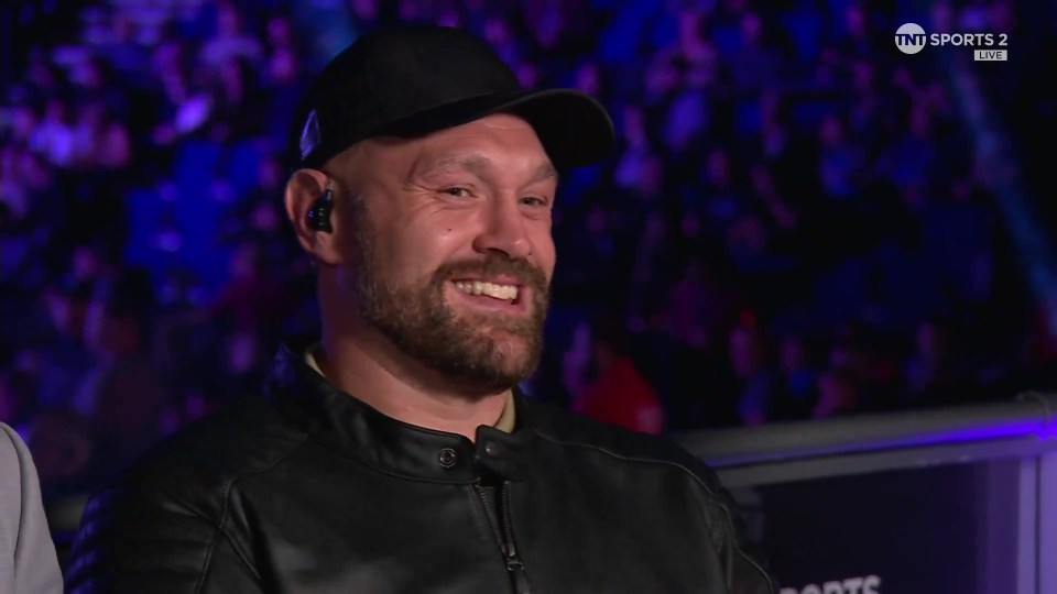 a man wearing a hat and ear buds is smiling in front of a screen that says tnt sports 2 live