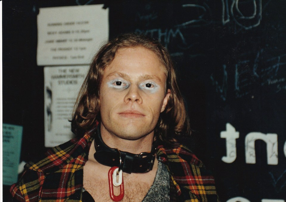 a man wearing a plaid shirt and a red tag around his neck