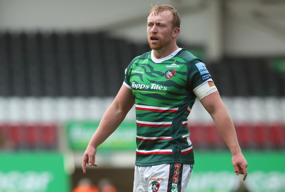 a rugby player wearing a green shirt that says topps tiles