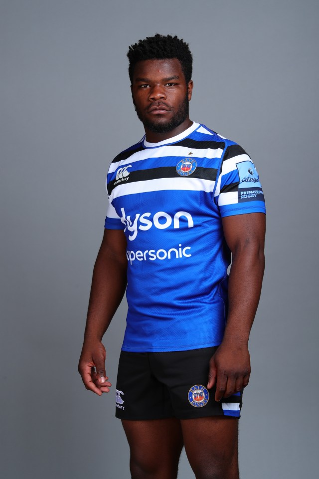 a man wearing a blue and white striped shirt with dyson on it