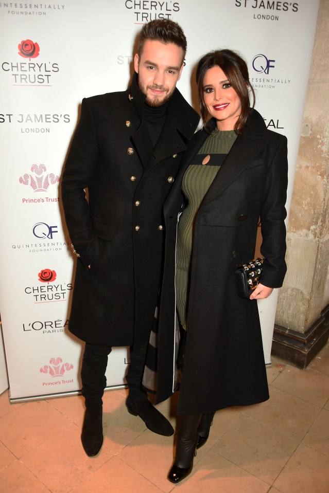 a man and a woman are standing in front of a sign that says cheryl 's trust