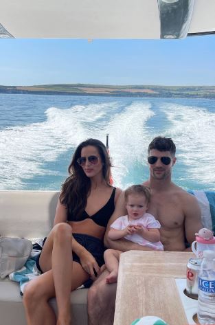 a man and a woman are sitting on a boat holding a baby .