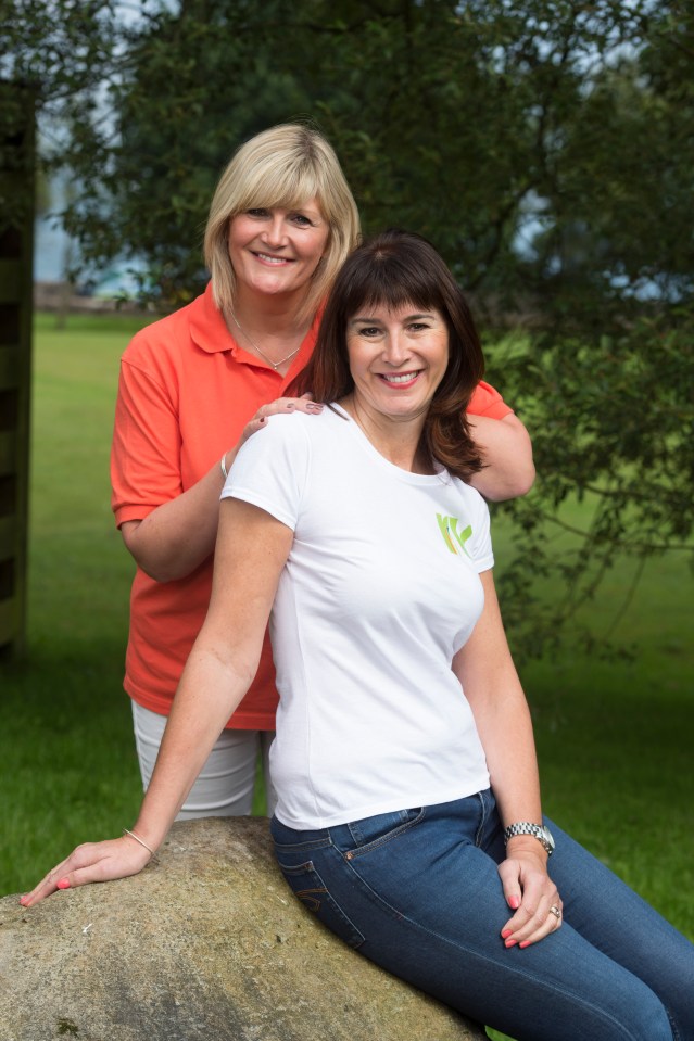 a woman in a white shirt with the letter k on it sits next to another woman