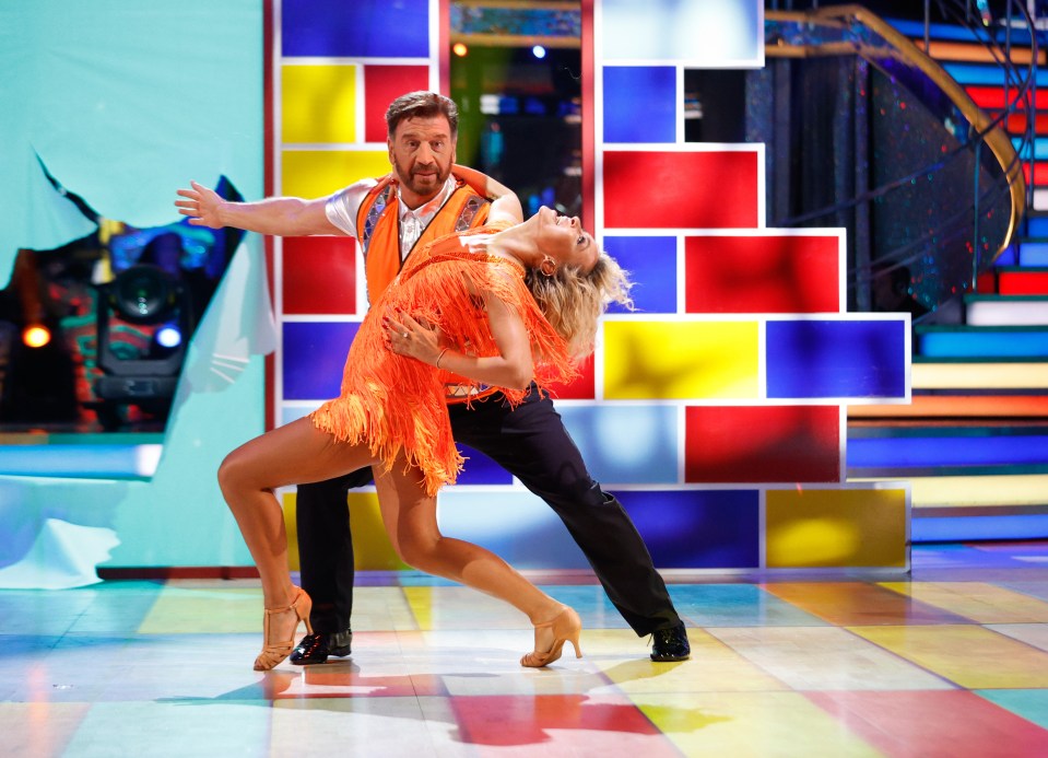 a man and a woman are dancing on a colorful stage