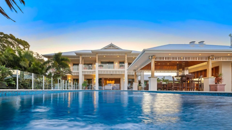 a large house with a swimming pool in front of it