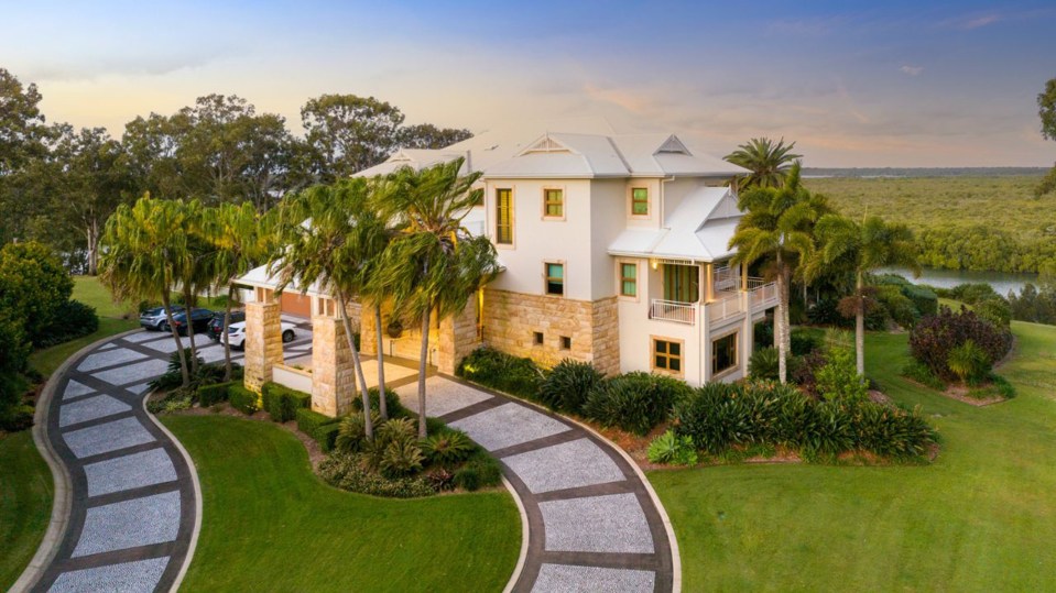 a large white house with a curved driveway leading to it