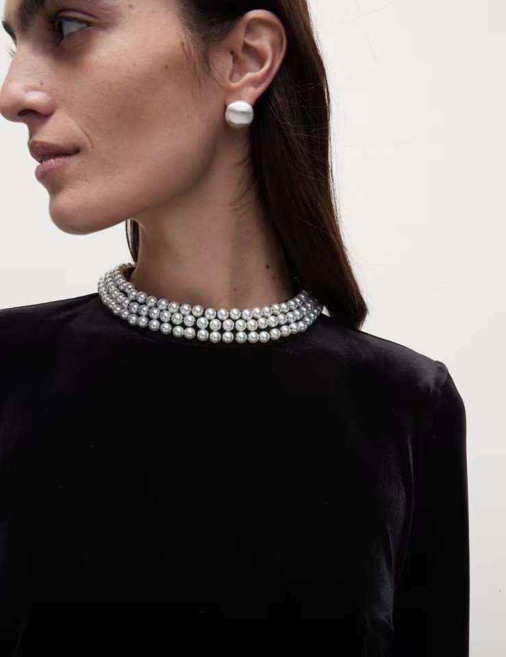 a woman wearing a pearl necklace and earrings