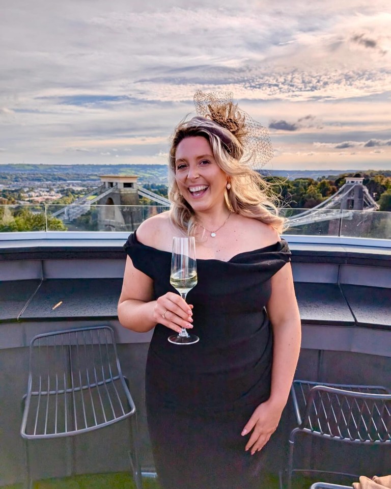 a woman in a black dress is holding a glass of wine