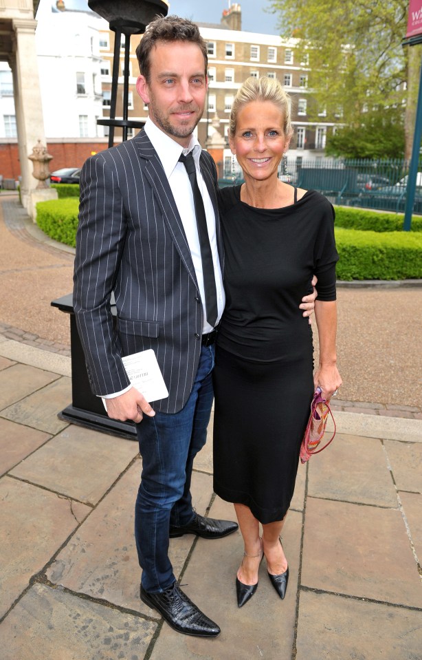 a man in a suit and tie stands next to a woman in a black dress