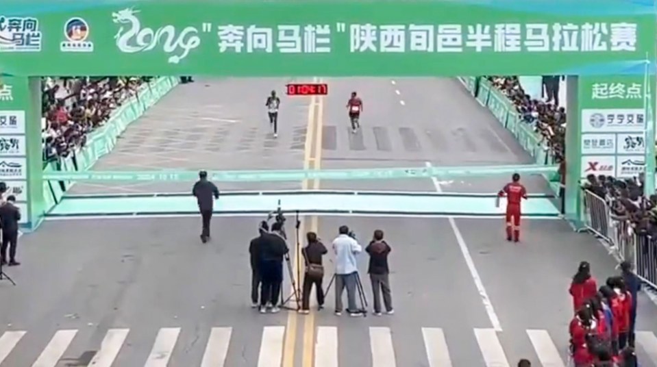 A runner dressed in red, on the right, suddenly appeared from the crowd at the end of a half marathon in china