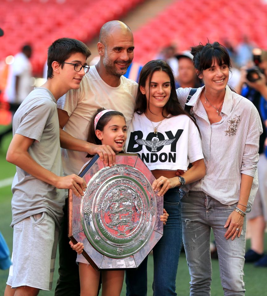 a family posing for a picture with a girl wearing a boy london shirt