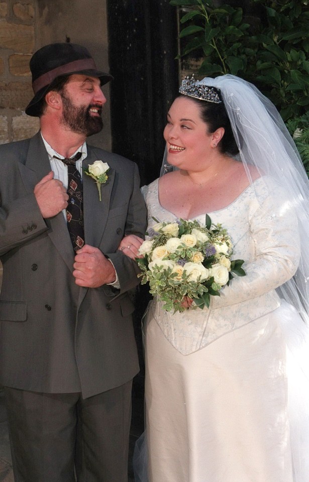 a bride and groom are posing for a picture and the bride is wearing a tiara