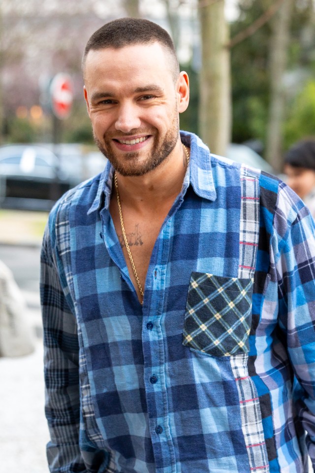 a man wearing a plaid shirt has a tattoo on his chest