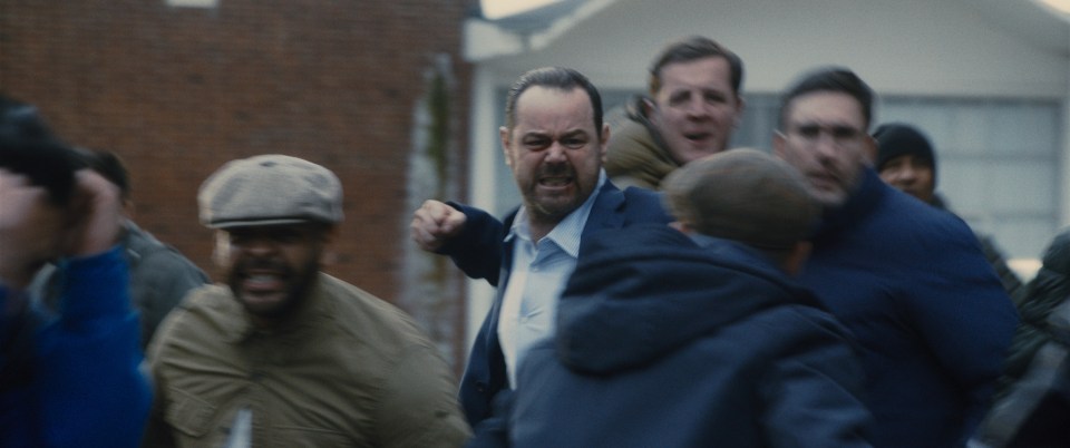 a man in a suit stands in a crowd of people