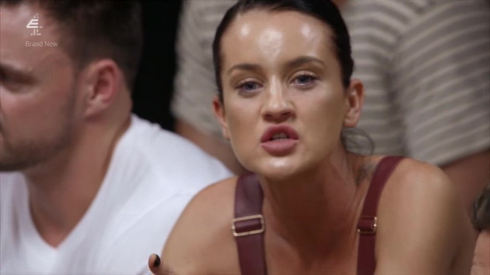 a woman is making a funny face while sitting in a crowd .