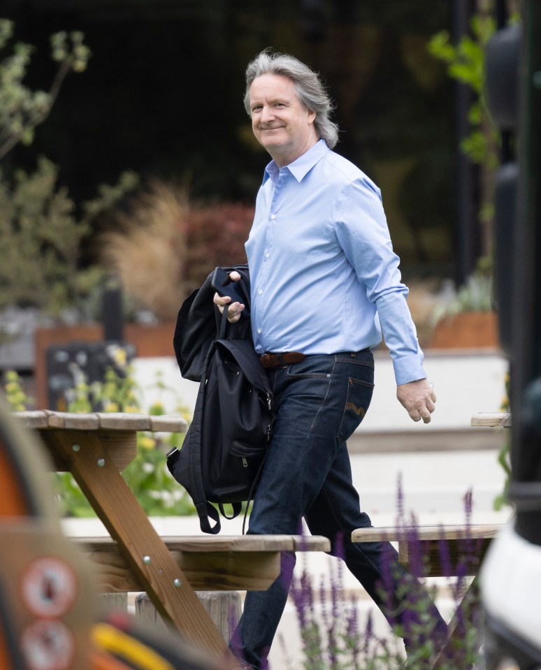 a man in a blue shirt carrying a black backpack