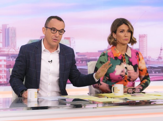 a man and a woman are sitting at a desk with a cup that says good morning britain