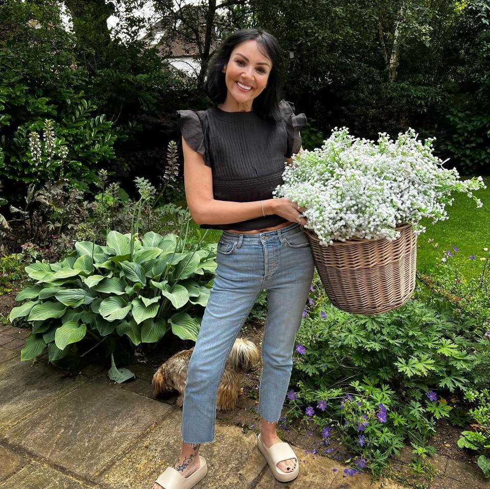 a woman is holding a basket full of white flowers