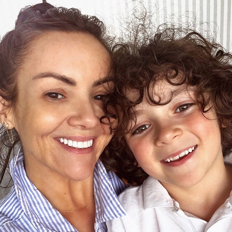 a woman and a young boy are smiling for the camera