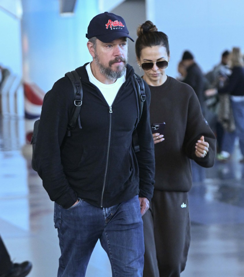 a man wearing an arnold 's hat walks with a woman