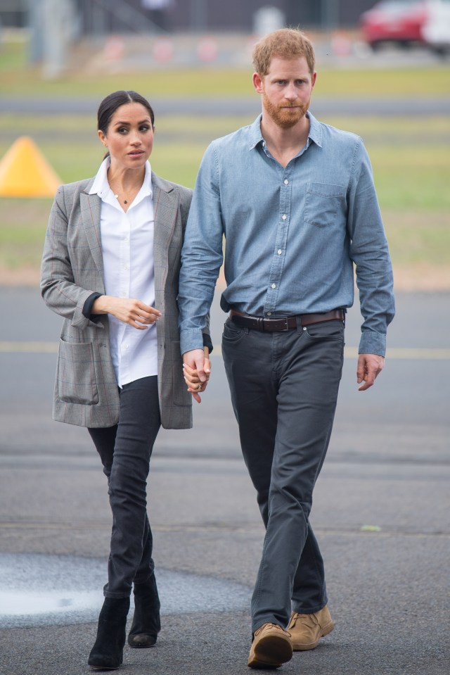 a man and a woman are walking down the street holding hands